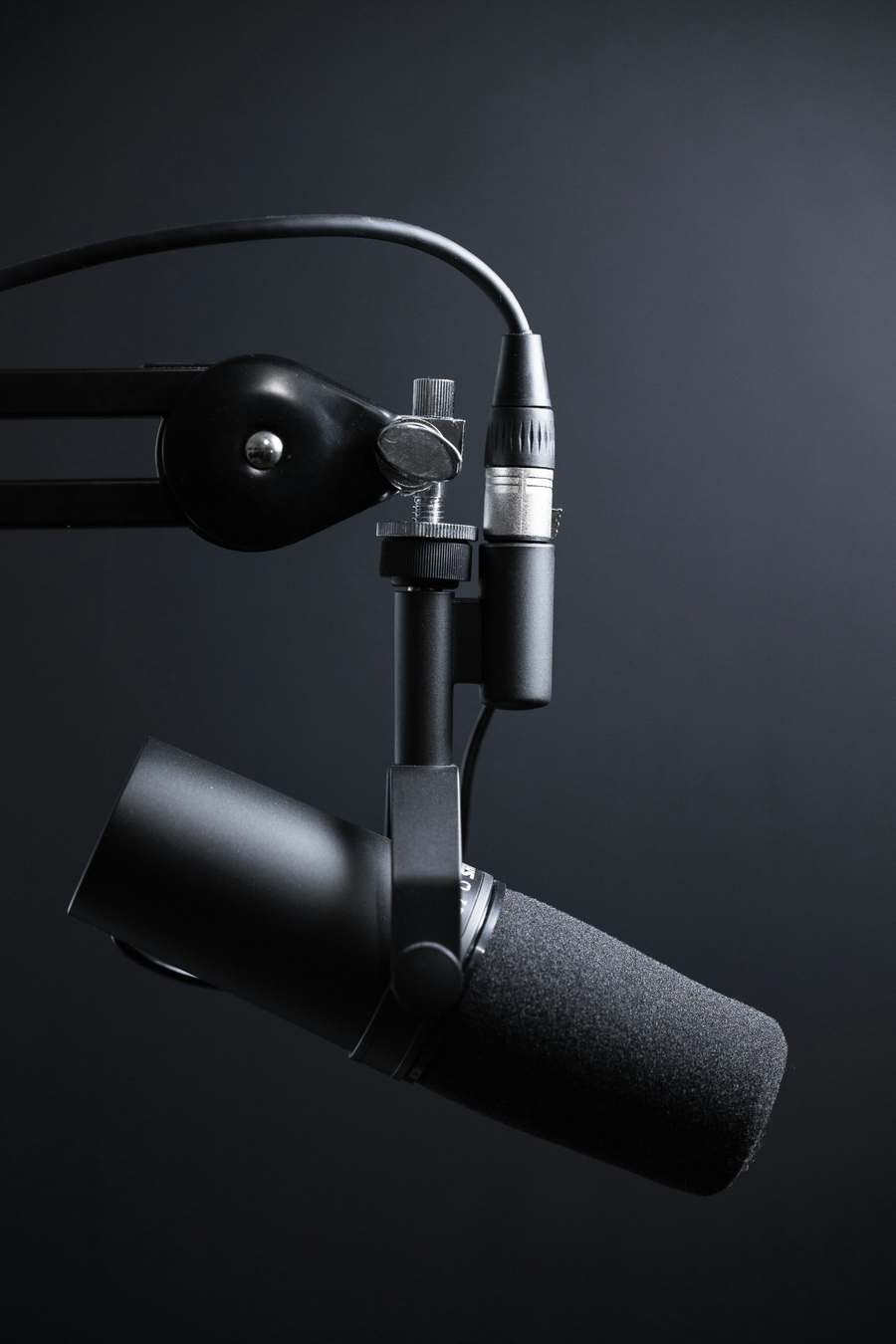 Black broadcast microphone on a studio boom arm