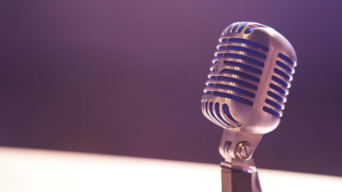 Vintage chrome microphone on a purple gradient